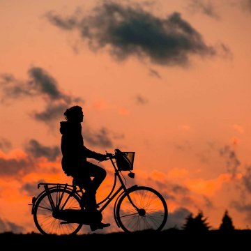 person riding a bike at sundown